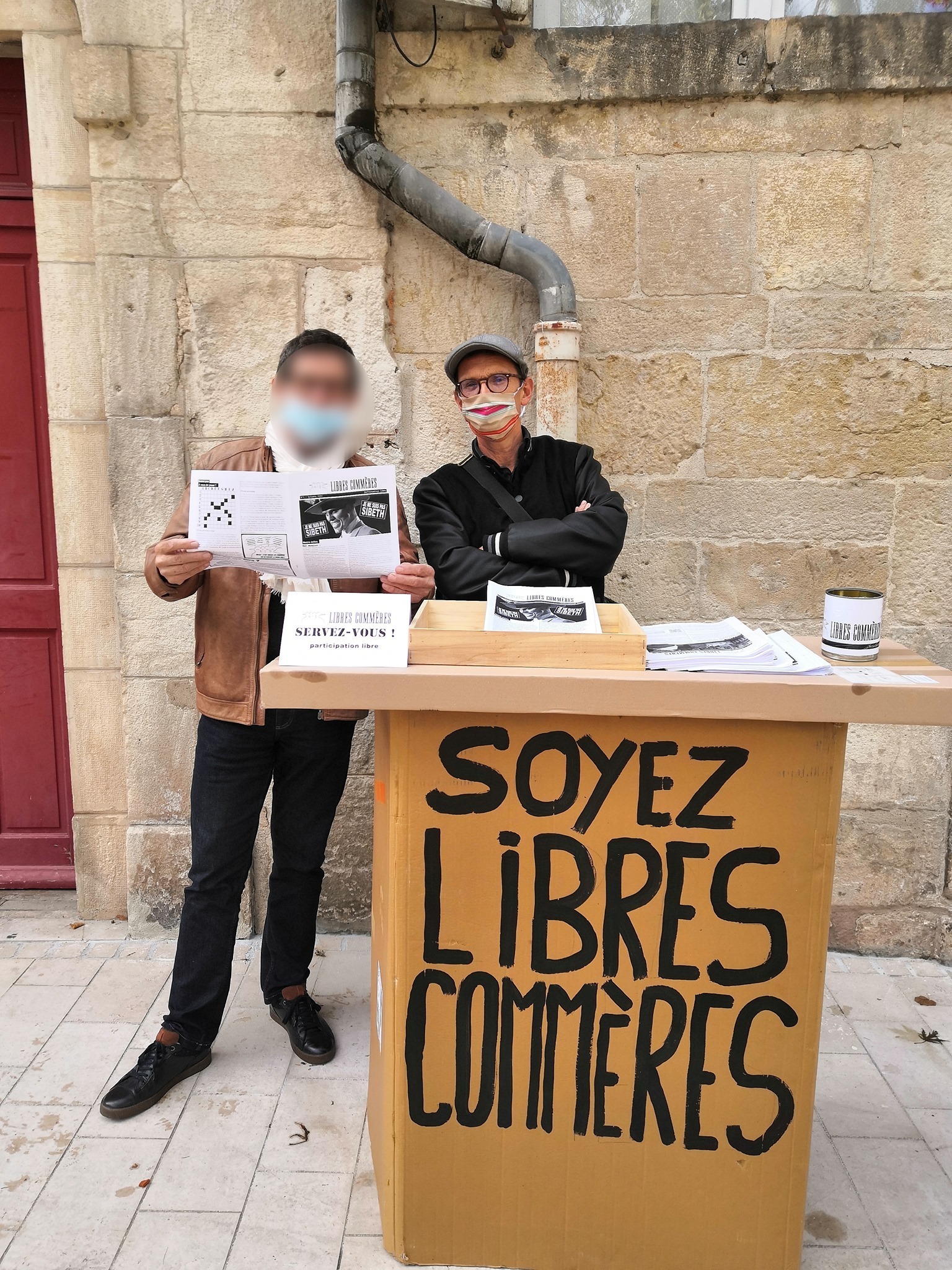 Image de notre stand en carton installé dans la rue pour une distribution de journaux.